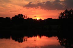Firey röd solnedgång över sjön Royaltyfria Bilder Firey röd solnedgång över sjön Royaltyfria Bilder