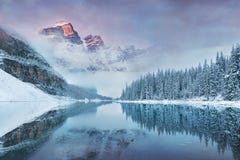First snow Morning at Moraine Lake in Banff National Park Alberta Canada. Snow-covered winter mountain lake in a winter atmosphere