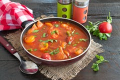Fish fillet cooked in tomato sauce with green peas and cherry tomatoes on a plate on a wooden background. Healthy eting concept. E Royalty Free Stock Photography Fish fillet cooked in tomato sauce with green peas and cherry tomatoes on a plate on a wooden background. Healthy eting concept. E Royalty Free Stock Photography