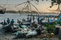 Fishermans travaillant aux filets de pêche chinois de plage pendant les heures d'or au fort Kochi, Kerala photos libres de droits Fishermans travaillant aux filets de pêche chinois de plage pendant les heures d'or au fort Kochi, Kerala photos libres de droits
