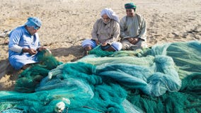 Fishermen in Oman preparing fishing nets, Sohar, Oman