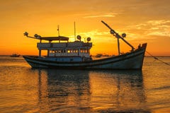 Fishing boat on the background of a golden sunset