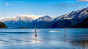Fiskebåten som heading upp Pitt Lake med maxima av de guld- öronen, sticker maximumet och andra maxima i kustberget arkivbilder Fiskebåten som heading upp Pitt Lake med maxima av de guld- öronen, sticker maximumet och andra maxima i kustberget arkivbilder