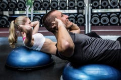 Fit couple doing sit ups on bosu ball stock photos Fit couple doing sit ups on bosu ball stock photos