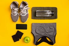 Fitness accessories on a yellow background. Sneakers, bottle of water, smart, towel and sport top. stock photos Fitness accessories on a yellow background. Sneakers, bottle of water, smart, towel and sport top. stock photos