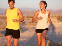 Fitness couple running jogging outside laughing Stock Photos