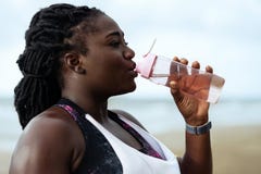 Fitness, people and healthy lifestyle- african woman drinking water after sport
