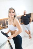 Fitness woman in kitchen, man in background. Husband and wife cooking together stock photos Fitness woman in kitchen, man in background. Husband and wife cooking together stock photos