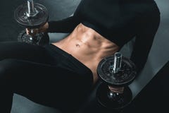 Fitness woman training with dumbbells and doing abs on mat.