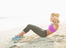 Fitness young woman doing abdominal crunch on beach stock photography Fitness young woman doing abdominal crunch on beach stock photography