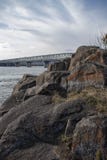 Fiume di Angara e rocce, ponte di Ust-Ilimsky sopra il fiume fotografia stock Fiume di Angara e rocce, ponte di Ust-Ilimsky sopra il fiume fotografia stock