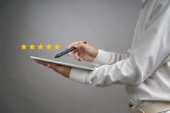 Five star rating or ranking, benchmarking concept. Man with tablet PC assesses service, hotel, restaurant