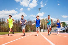 Five teenage sprinters running together on a track royalty free stock image Five teenage sprinters running together on a track royalty free stock image