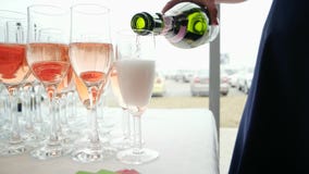 Fizzy drink pouring in glasses from bottle, woman hand holding bottle and pouring rose champagne stock video Fizzy drink pouring in glasses from bottle, woman hand holding bottle and pouring rose champagne stock video