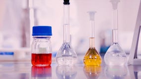 Flacons et bechers de laboratoire avec des liquides de différentes couleurs sur la table de laboratoire images libres de droits Flacons et bechers de laboratoire avec des liquides de différentes couleurs sur la table de laboratoire images libres de droits