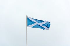 The flag of Scotland waving on a pole stock image The flag of Scotland waving on a pole stock image