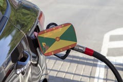 Flaga Grenada na samochodowym ` s paliwa napełniacza łopocie obraz royalty free Flaga Grenada na samochodowym ` s paliwa napełniacza łopocie obraz royalty free