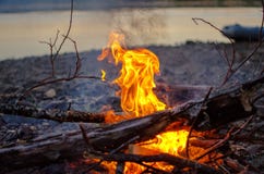 Flamme eines Lagerfeuers durch den Fluss lizenzfreies stockbild Flamme eines Lagerfeuers durch den Fluss lizenzfreies stockbild