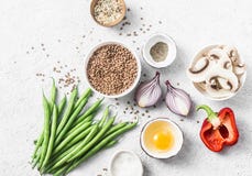 Flat lay healthy vegetarian food ingredients for lunch on a light background, top view. Buckwheat, green beans, sweet peppers, red Stock Images Flat lay healthy vegetarian food ingredients for lunch on a light background, top view. Buckwheat, green beans, sweet peppers, red Stock Images