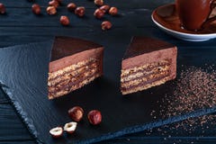 Close up view on sliced hazelnut cake with cacao on a black background and a plate. royalty free stock image Close up view on sliced hazelnut cake with cacao on a black background and a plate. royalty free stock image