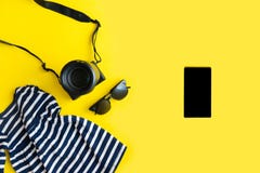 Flat lay traveler accessories on yellow background with blue dress, camera and sunglasses. Summer background concept royalty free stock photography Flat lay traveler accessories on yellow background with blue dress, camera and sunglasses. Summer background concept royalty free stock photography