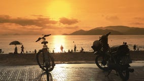 Flera motorcyklar står i parkeringsplatsen på invallningen av Nha Trang vietnam Aftontid och solnedgång Flera motorcyklar står i parkeringsplatsen på invallningen av Nha Trang vietnam Aftontid och solnedgång