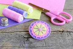 Fleur ronde sentie décorée des perles Le rond mignon fait main a senti la fleur, ciseaux, fil, feuilles colorées de feutre, dé photos stock Fleur ronde sentie décorée des perles Le rond mignon fait main a senti la fleur, ciseaux, fil, feuilles colorées de feutre, dé photos stock