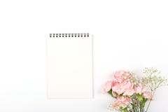 Fleurs et un bloc-notes sur le fond blanc photographie stock Fleurs et un bloc-notes sur le fond blanc photographie stock