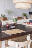 Fleurs sur la table en bois sous la lampe dans l'intérieur lumineux moderne de salle à manger avec la chaise Photo réelle images stock Fleurs sur la table en bois sous la lampe dans l'intérieur lumineux moderne de salle à manger avec la chaise Photo réelle images stock