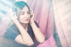 Flicka i h?rlurar som lyssnar till musik och tycker om att le arkivbilder Flicka i h?rlurar som lyssnar till musik och tycker om att le arkivbilder