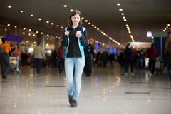 Flicka som använder mobiltelefonen i flygplats Fotografering för Bildbyråer Flicka som använder mobiltelefonen i flygplats Fotografering för Bildbyråer
