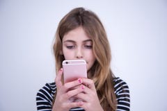 Flicka som använder rosa färgtelefonen i seriusögonblick royaltyfri bild Flicka som använder rosa färgtelefonen i seriusögonblick royaltyfri bild