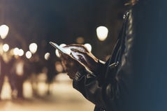 Flicka som pekar fingret på den smarta telefonen för skärm på ljus för bakgrundsbelysningfärg i atmosfärisk stad för natt, använd royaltyfria bilder Flicka som pekar fingret på den smarta telefonen för skärm på ljus för bakgrundsbelysningfärg i atmosfärisk stad för natt, använd royaltyfria bilder
