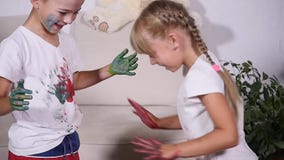 Flickan lämnade en avtryck av hennes hand på T-tröja för pojke` s, ultrarapid stock video Flickan lämnade en avtryck av hennes hand på T-tröja för pojke` s, ultrarapid stock video
