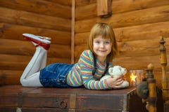 Flickan Masha ligger på den gamla bröstkorgen royaltyfria bilder Flickan Masha ligger på den gamla bröstkorgen royaltyfria bilder