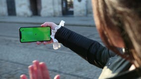 Flickan talar på en smartphone greenscreen av telefonen Vinkar handen till folket som de ser på skärmen stock video Flickan talar på en smartphone greenscreen av telefonen Vinkar handen till folket som de ser på skärmen stock video