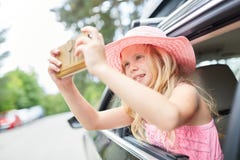Flickan tar ett selfiefoto i bilen royaltyfri fotografi Flickan tar ett selfiefoto i bilen royaltyfri fotografi
