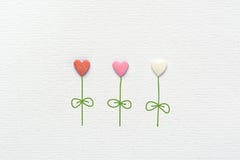 Flores coloridos na forma do coração feita das folhas dos vapores de Sugar Candy Sprinkles Hand Drawn no papel branco da aquarela foto de stock royalty free Flores coloridos na forma do coração feita das folhas dos vapores de Sugar Candy Sprinkles Hand Drawn no papel branco da aquarela foto de stock royalty free