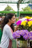 Flores de compra de la mujer joven Imagen de archivo Flores de compra de la mujer joven Imagen de archivo