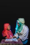 FLORES, ΙΝΔΟΝΗΣΊΑ 25 ΙΟΥΝΊΟΥ 2014: Μια αδελφή hijab διδάσκει την αδελφή της που φορά επίσης ένα hijab για να διαβάσει το quran σε στοκ εικόνες με δικαίωμα ελεύθερης χρήσης FLORES, ΙΝΔΟΝΗΣΊΑ 25 ΙΟΥΝΊΟΥ 2014: Μια αδελφή hijab διδάσκει την αδελφή της που φορά επίσης ένα hijab για να διαβάσει το quran σε στοκ εικόνες με δικαίωμα ελεύθερης χρήσης