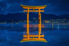 Flutuador gigante da porta do torii na água no crepúsculo imagem de stock royalty free Flutuador gigante da porta do torii na água no crepúsculo imagem de stock royalty free