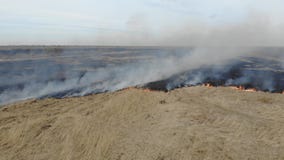 Flyg- sikt av att bränna torrt gräs i fältet, panna Katastrof och nöd- händelser, negativ inverkan på naturen stock video Flyg- sikt av att bränna torrt gräs i fältet, panna Katastrof och nöd- händelser, negativ inverkan på naturen stock video