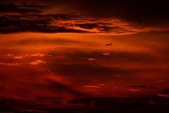 Flygplanlandning eller start i solnedgången med röd himmel i Bucharest den internationella flygplatsen, spotting för slätt arkivbilder Flygplanlandning eller start i solnedgången med röd himmel i Bucharest den internationella flygplatsen, spotting för slätt arkivbilder