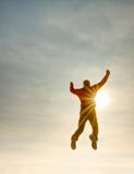 Flying man. Silhouette of jumping man and sunset sky. Sun flare stock photo Flying man. Silhouette of jumping man and sunset sky. Sun flare stock photo