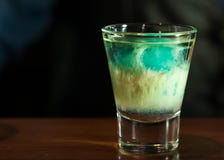 Foco selectivo de la bebida azul y blanca del alcohol en vaso de medida claro fotos de archivo libres de regalías Foco selectivo de la bebida azul y blanca del alcohol en vaso de medida claro fotos de archivo libres de regalías