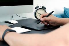 Focus on the busy graphic designer working on computer by digital pen mouse stock images Focus on the busy graphic designer working on computer by digital pen mouse stock images