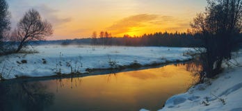 Frosty foggy winter panoramic landscape with small forest river and rising sun. stock photography Frosty foggy winter panoramic landscape with small forest river and rising sun. stock photography