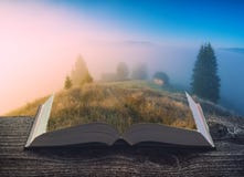 Foggy mountain valley on a book