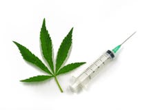 Foglia e siringa della cannabis su fondo bianco immagini stock Foglia e siringa della cannabis su fondo bianco immagini stock
