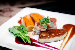 Foie Gras med bacontranbärsås och den caramelized bananen royaltyfri bild Foie Gras med bacontranbärsås och den caramelized bananen royaltyfri bild